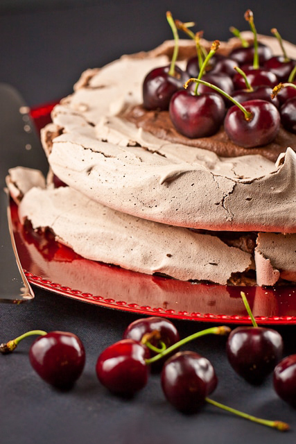 black forest pavlova being served with cherries