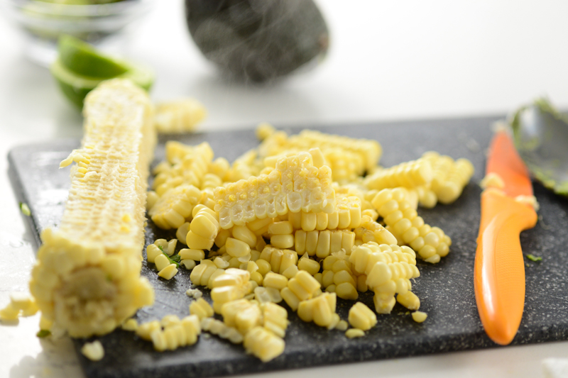 corn being cut for vegan burrito bowls