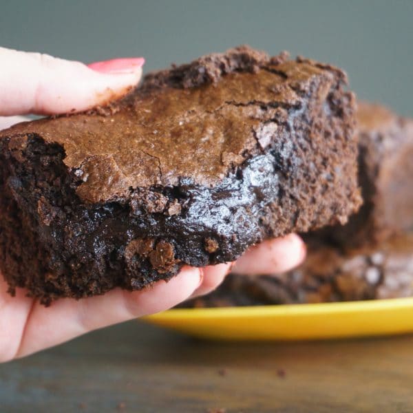 holding an olive oil brownie to eat