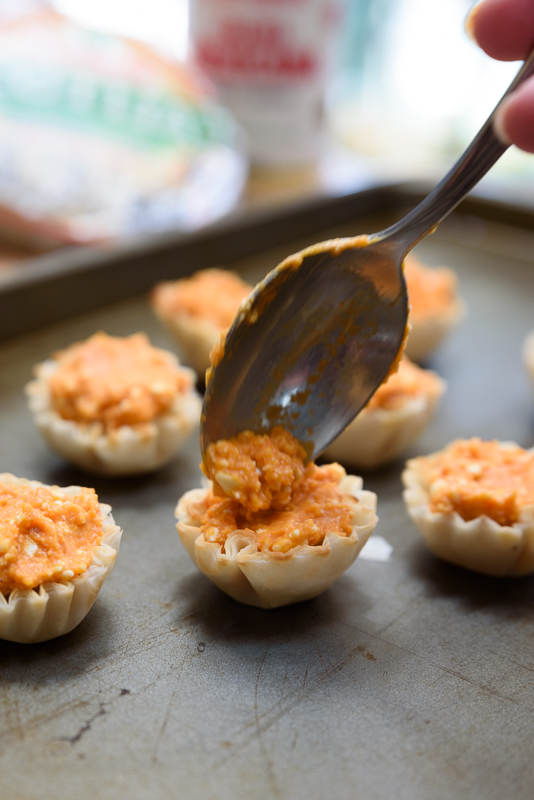 filling phyllo cups with pumpkin filling