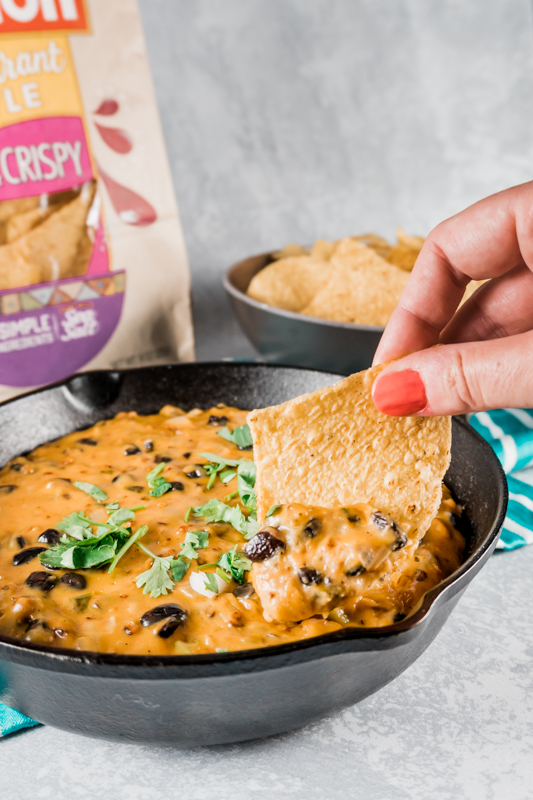 dipping chips into the vegetarian chili cheese dip