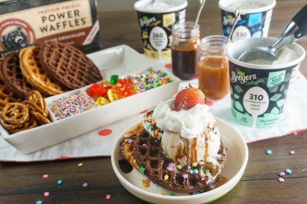waffle sundae in front of a waffle sundae bar with lots of toppings