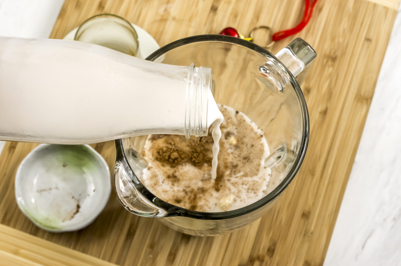 adding coconut milk to the vegan eggnog