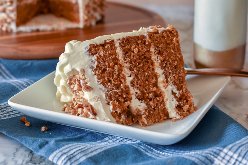 vegan carrot cake with cream cheese frosting being served on a white dish