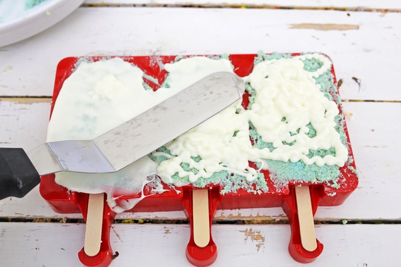 cakesicles being topped with white chocolate