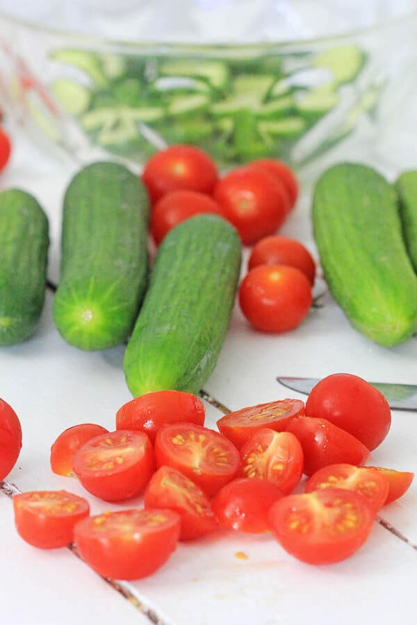 sliced cherry tomatoes and whole cucumbers