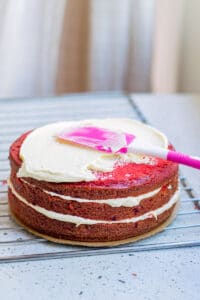icing the layers of red velvet cake