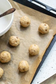 arranging vegan oatmeal raisin cookies on a baking sheet
