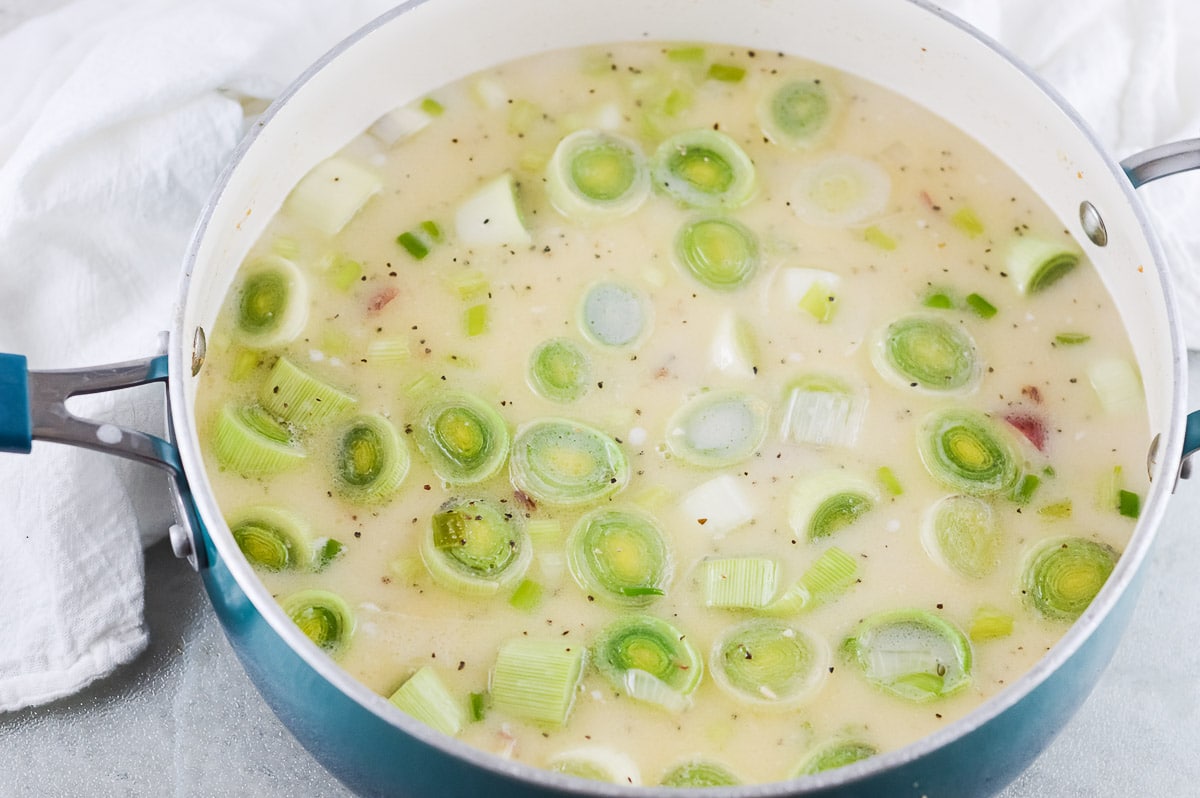 vegan potato leek soup in pot with seasoning