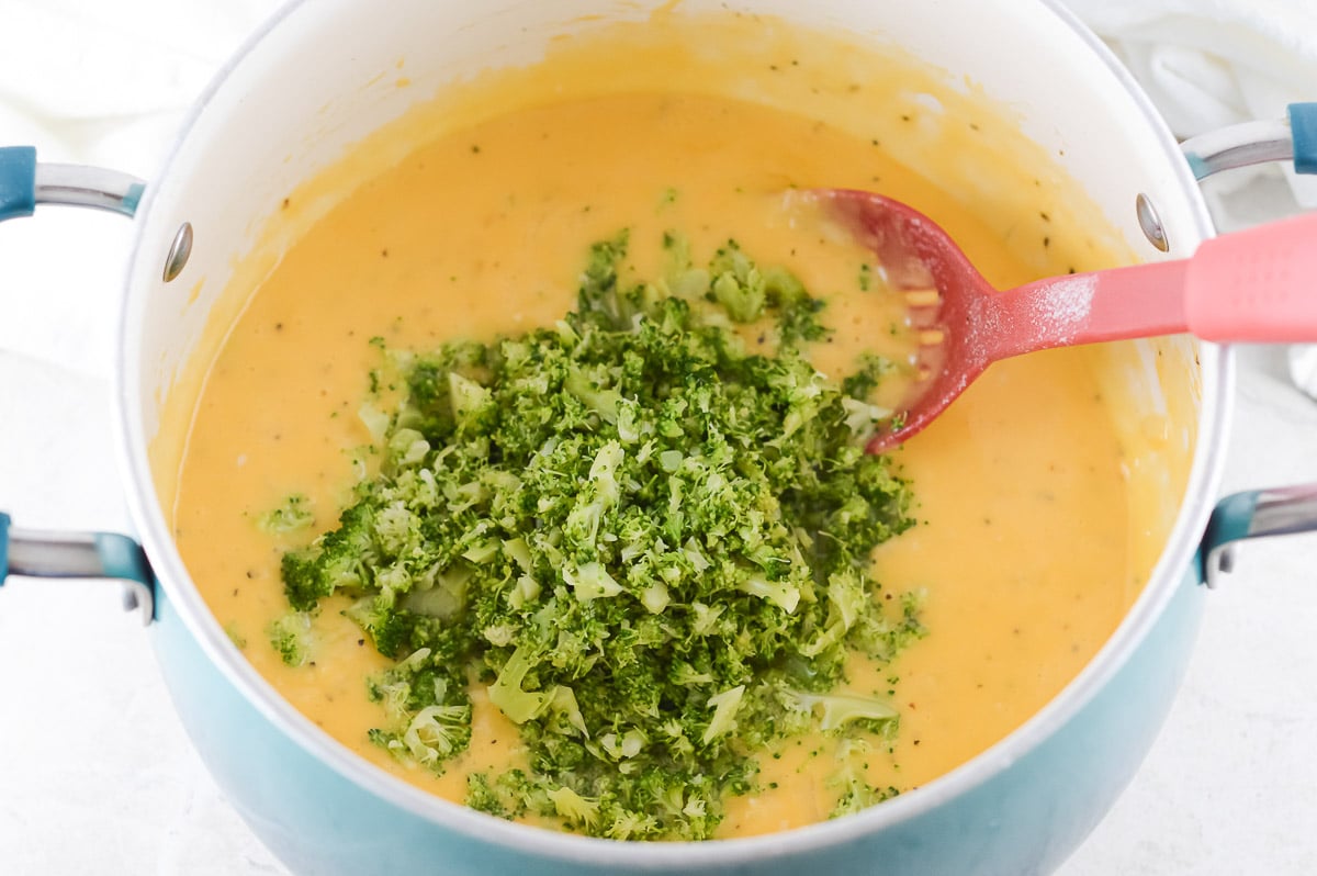 adding broccoli to the soup