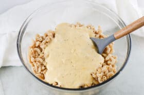 mixing dairy free cheese sauce into pasta