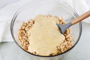 mixing dairy free cheese sauce into pasta