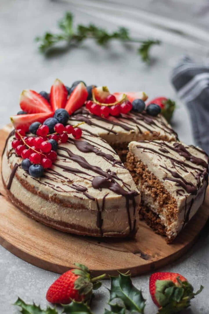 vegan gingerbread cake topped with coconut frosting and fresh fruit