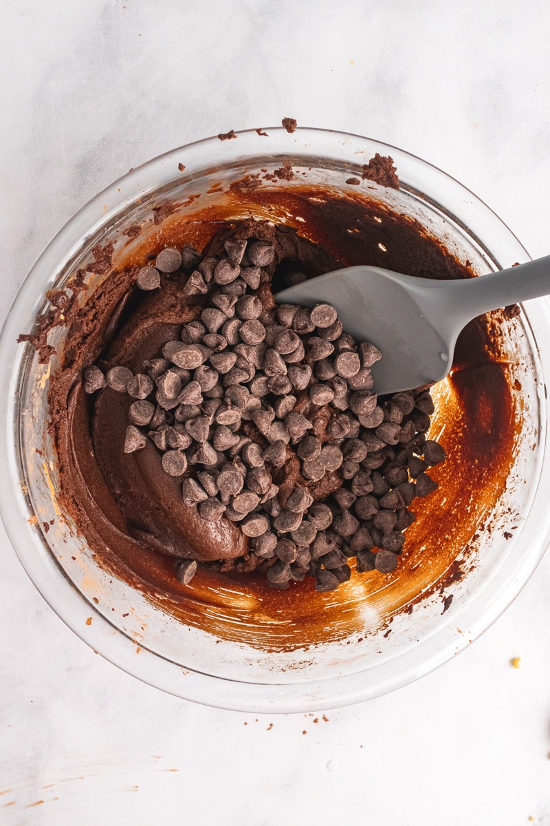 folding chocolate chips into edible brownie batter