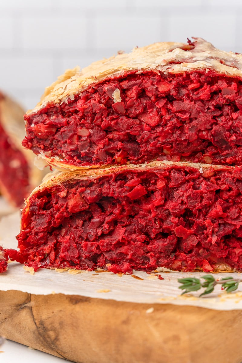 slices of vegan beet wellington stacked on a cutting board