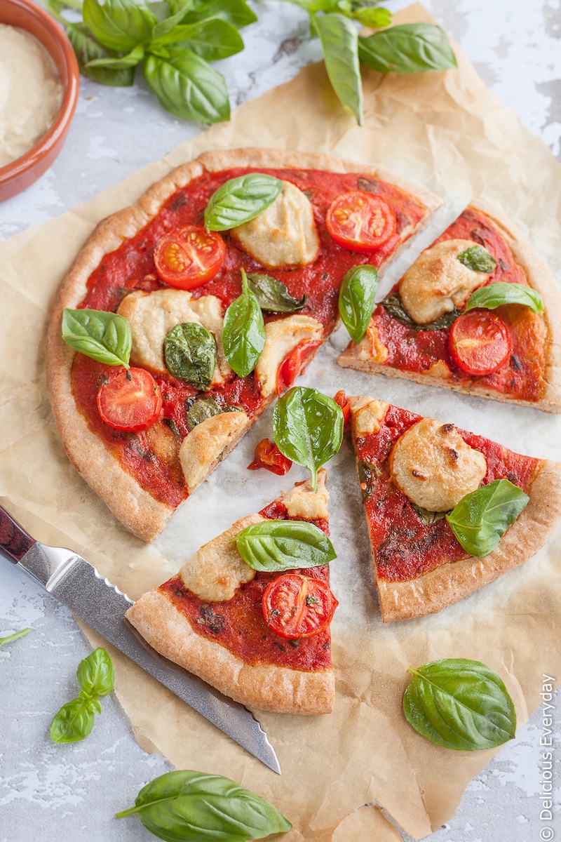 With this Margherita Pizza Recipe you can enjoy all the flavours of the Italian classic, the Margherita pizza in vegan form. Topped with tomatoes and basil and a creamy cashew ricotta this cheeseless pizza is sure to be a hit! | Click for the recipe