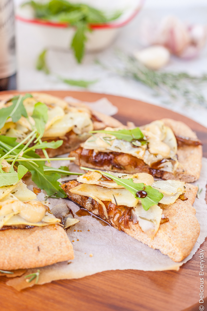 Nutty spelt makes a perfect base for this caramelised onion and vegan potato pizza recipe. Topped with balsamic garlic cashew aioli and a few rocket (arugula) leaves its the perfect thing to serve to friends over a few drinks. | Get the recipe at deliciouseveryday.com