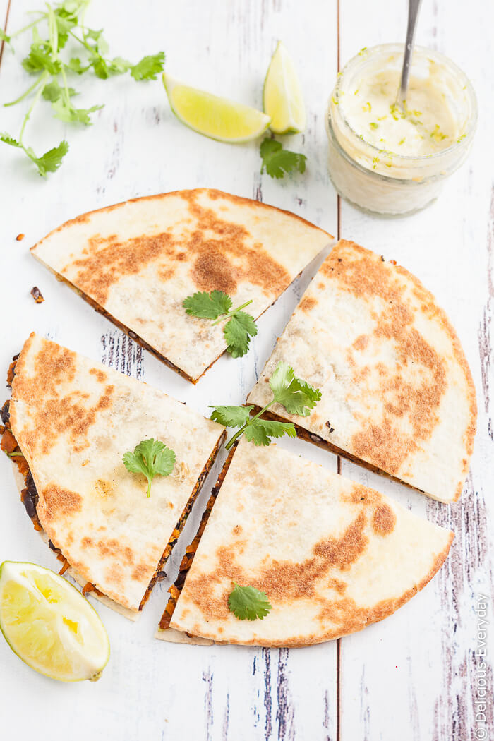 Vegan Sweet Potato Quesadilla Recipe - With black beans, smoked paprika and coriander and ground cumin, these vegan sweet potato quesadillas are hearty and packed full of flavour. Serve with a generous dollop of lime cashew cream and an extra squeeze of lime along with a side salad for a delicious weeknight dinner. | Click to get the recipe
