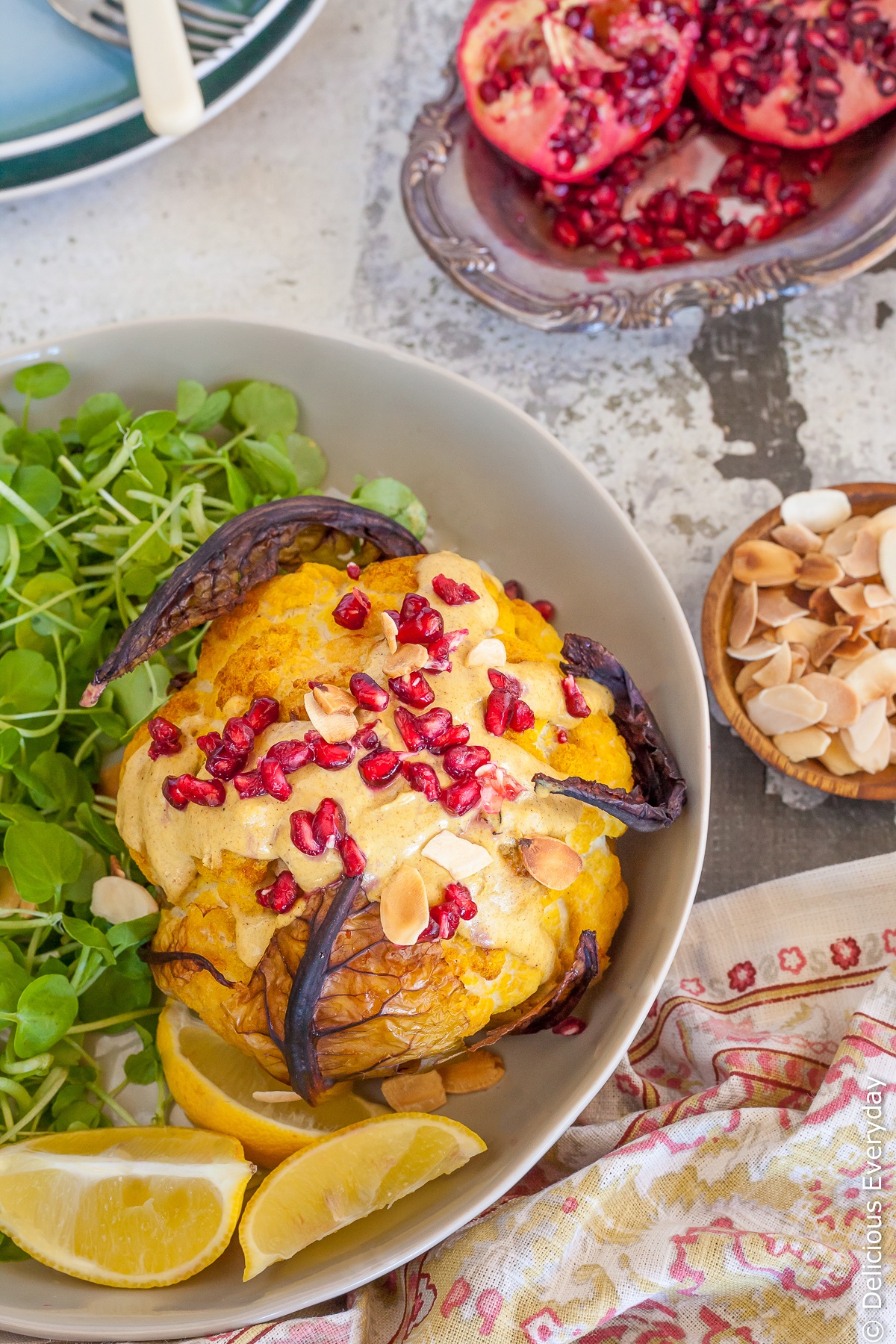This Whole Roasted Cauliflower Head recipe is a wonderful way to enjoy cauliflower as baking it really amps up the flavour. Bathed in an nutty Tahini Sauce with gorgeously fragrant ras el hanout topped with pomegranate seeds and toasted almonds its a far cry from the cauliflower you pushed around your plate growing up!
